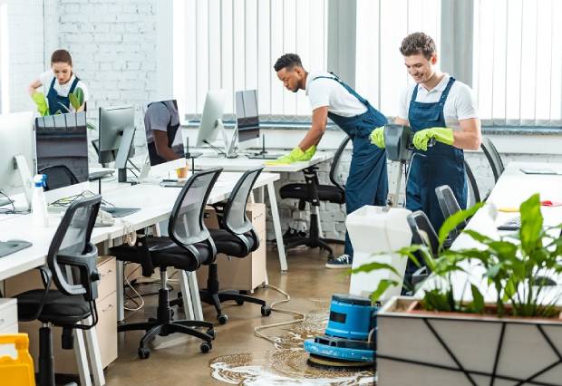 Black Mountain Cleaners team performing commercial cleaning in an office, scrubbing floors and sanitizing workstations for a clean and professional workspace.